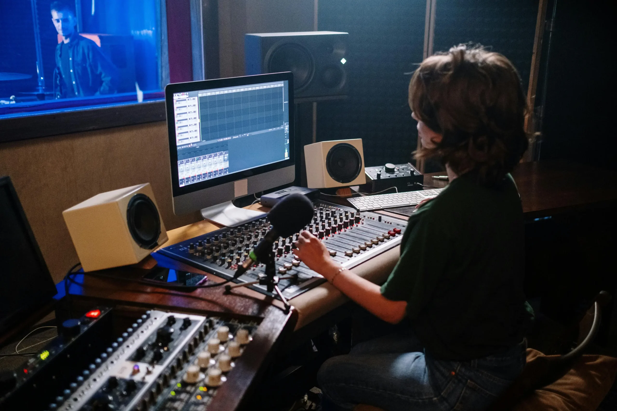 Woman at sound mixing desk in voiceovercafe.co.uk voiceover agency recording a commercial voiceover